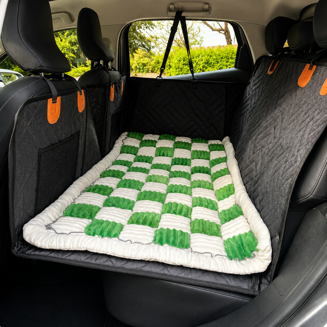 Green checkerboard Luxe Dog Bed on a car back seat