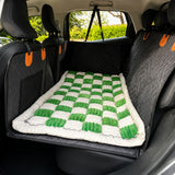 Green checkerboard Luxe Dog Bed on a car back seat